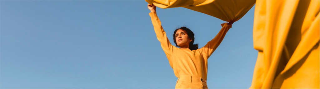 Mujer sosteniendo tela impulsada por el viento